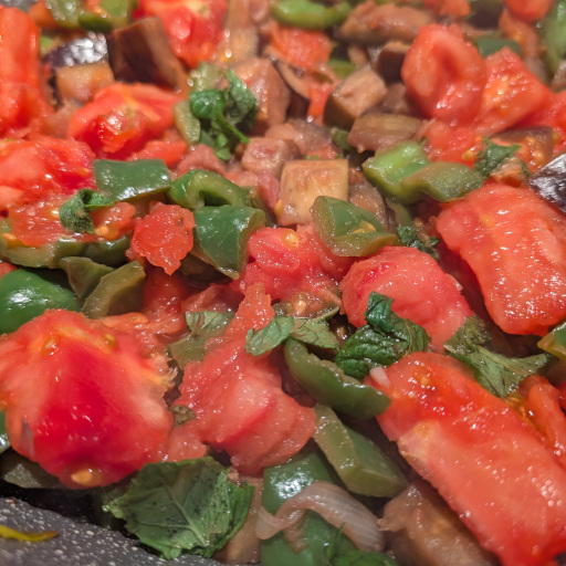 Chopped tomatoes and fresh herbs added to the kapunata base